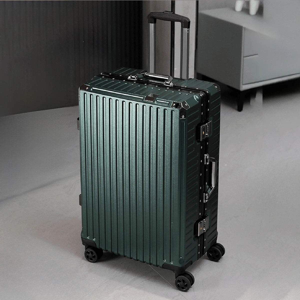 Green suitcase with a ribbed texture on a gray floor.