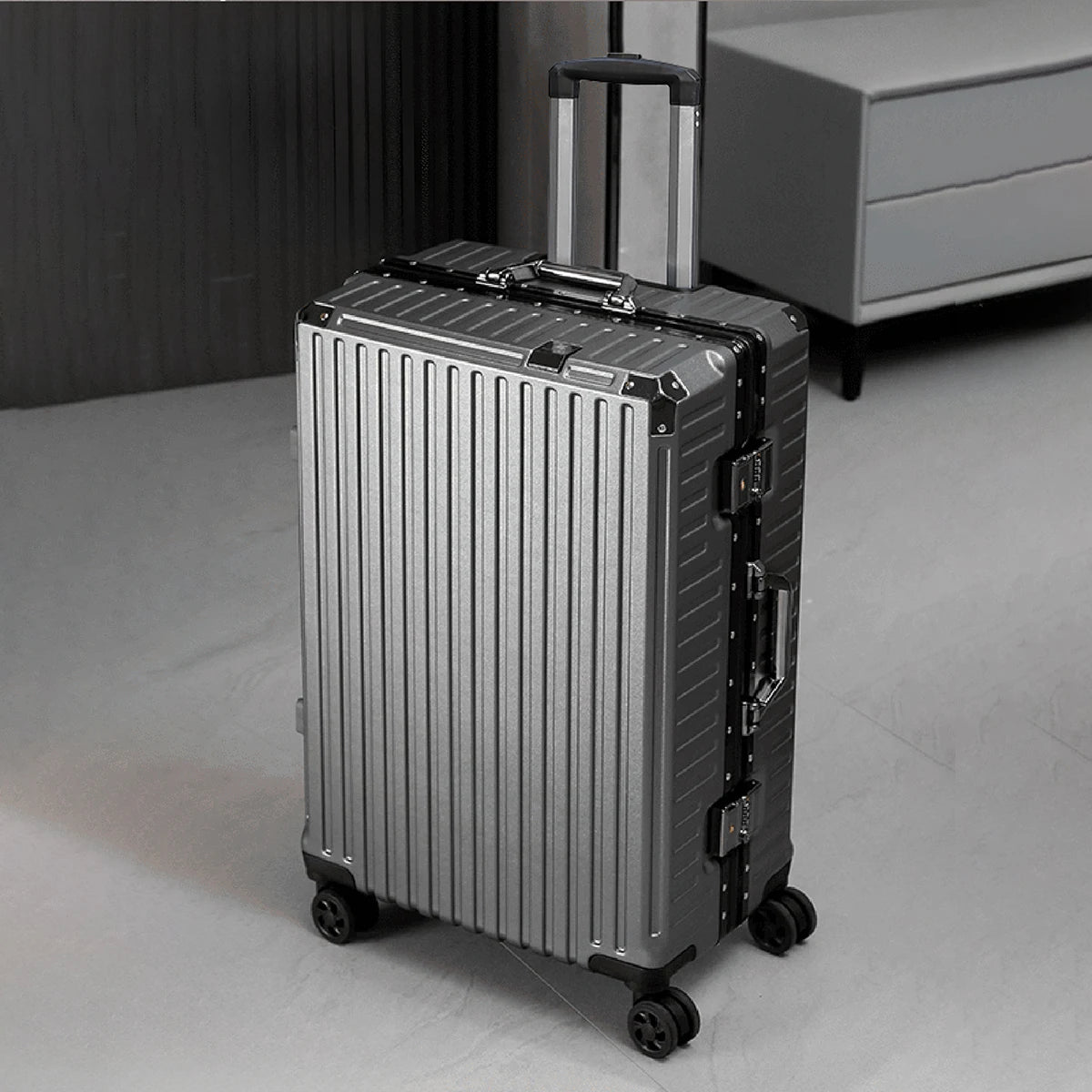 Silver suitcase with black accents on a light gray floor.