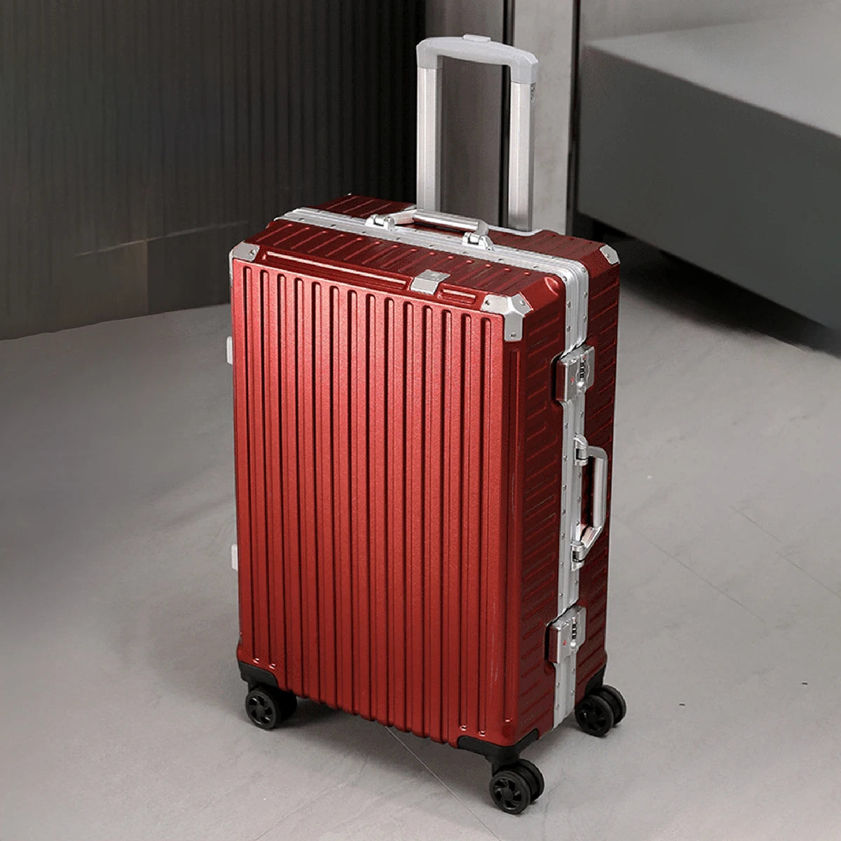 Red suitcase with silver accents on a gray floor