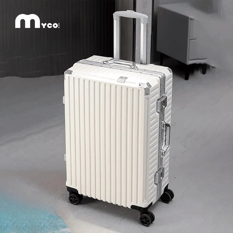 White suitcase with black wheels on a gray floor, featuring the Myco brand logo.