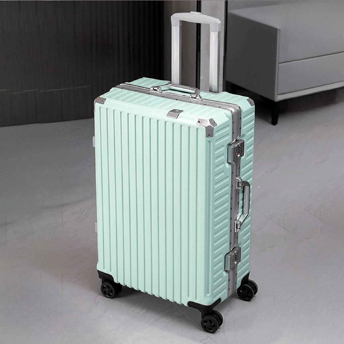 Light blue suitcase with silver accents on a gray floor.
