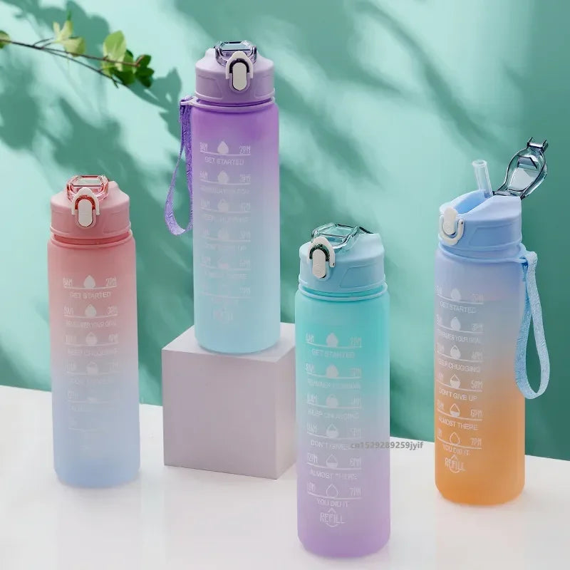 Set of colorful gradient water bottles on a light surface with a green background